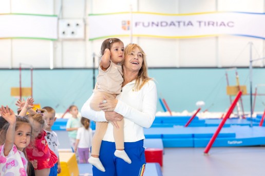 Nadia Comăneci alături de un copil participant la selecția de gimnastică