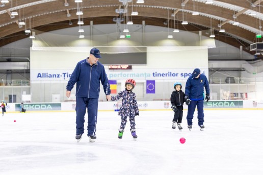 Copil însoțit de antrenor la selecția de patinaj